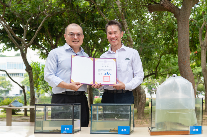 清華大學校長高為元（右）致贈感謝狀給捐贈魚苗經費的達發科技董事長謝清江。