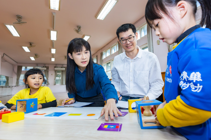 清華幼教系特聘教授周育如(左二)與生科系副教授郭崇涵(右二)引導幼兒在遊戲中合作。圖片