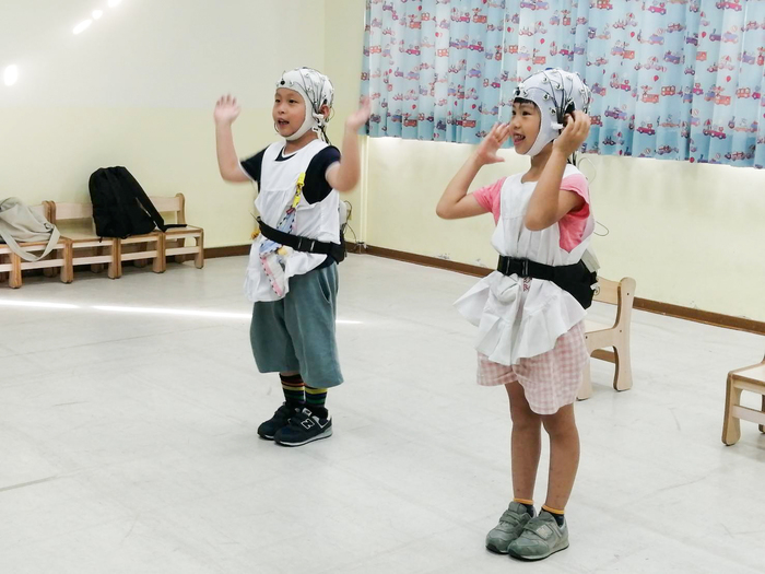 清華幼教系特聘教授周育如進行幼兒互動腦波實驗,嘗試透過音樂律動提升幼兒自我調控能力。圖片