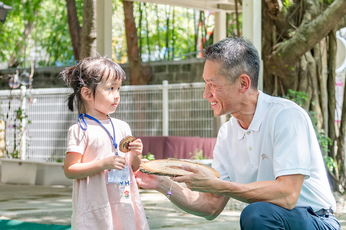 新生代表徐小妹妹準備小木牌遞給校長高為元，請他寫下祝福。