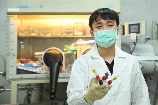 盧奕廷在清華大學重建英國的實驗設備,手上是他設計的電化學反應裝置圖片