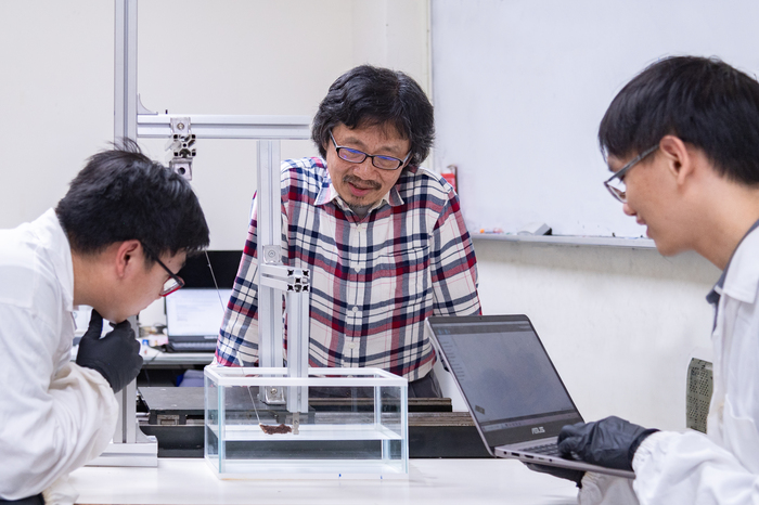 清華物理系教授洪在明(中)指導研究生陳中皓(左)、謝廷珩(右)研究紅火蟻結筏成因。
