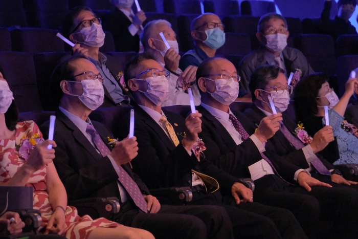 清華大學今舉行111週年校慶大會，台下師長拿起紫色螢光棒揮舞、聆聽演奏。