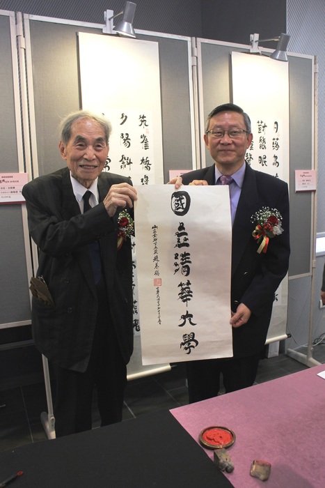 趙慕鶴老師(左)當場揮毫落款將鳥蟲體書法作品「國立清華大學」六字送給學校。(右為清華大學賀陳弘校長)