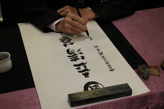 趙慕鶴老師(左)當場揮毫落款將鳥蟲體書法作品「國立清華大學」六字送給學校。