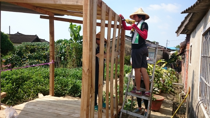 學生在土溝村工作人員的指導下，搭建給村民的「賣菜亭」