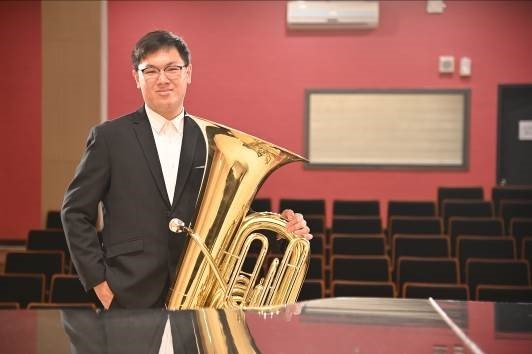 雙主修音樂系及科管院學士班的大三生魏崇軒吹奏低音號。