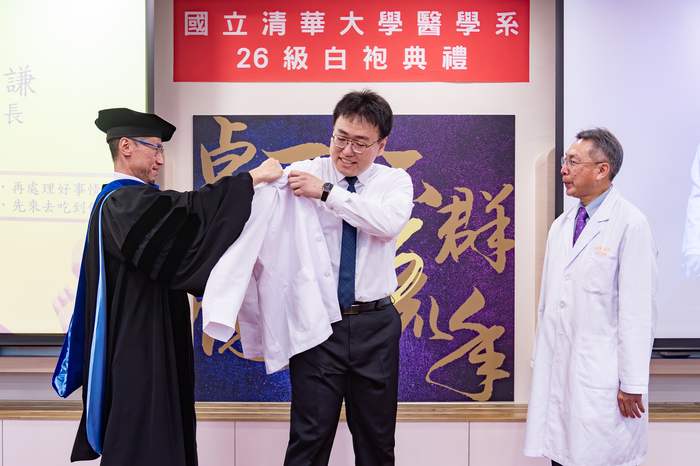清華大學首屆醫學生授袍，校長高為元（左）為學生沈和謙披上白袍。