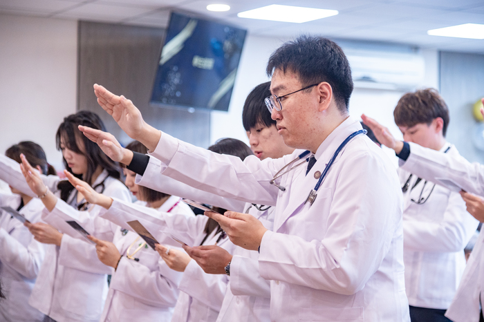 披上白袍的醫學生們宣讀誓詞，將成為醫生的初衷銘記在心。
