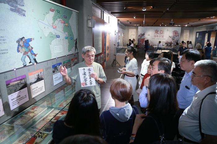 國立清華大學中文系楊儒賓教授(左一)在「東亞百年巨變：甲午戰爭、乙未抗日紀念文物特展」為觀眾逐一導覽解說，吸引觀眾駐足欲罷不能。